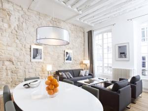 ein Wohnzimmer mit einem weißen Tisch und Stühlen in der Unterkunft LivinParis - Luxury 2 Bedrooms Le Marais I in Paris