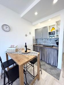 a kitchen and dining room with a wooden table and chairs at Sunset Erice Beach in Trapani