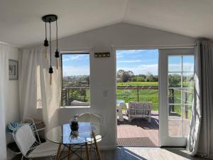 a dining room with a glass table and a balcony at 30 PCT OFF! Malibu Serene Cabin, Ocean View, Beach in Malibu