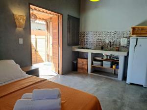 a bedroom with a bed and a kitchen with a refrigerator at Casa Om - Vila de São Jorge in Sao Jorge