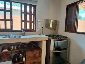 a kitchen with a stove top oven next to a sink at Casa Om - Vila de São Jorge in Sao Jorge