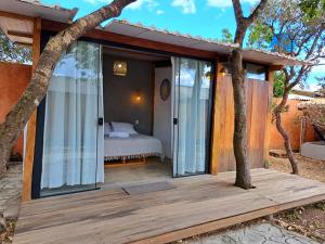 um quarto com uma cama num deque de madeira em Casa Om - Vila de São Jorge em São Jorge