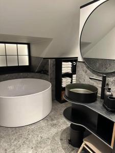 a bathroom with a large tub and a round mirror at Panoramavy nära Gbg och natur in Olofstorp +33 photos