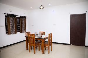 a dining room with a table and chairs at JDP Villa 2 Bhk House in Ooty