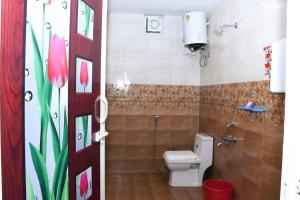 a bathroom with a toilet and a shower with pink flowers at JDP Villa 2 Bhk House in Ooty +20 photos