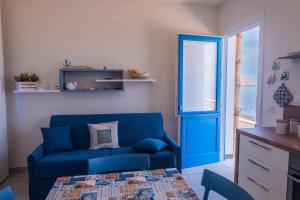 un soggiorno con divano blu e tavolo di casa D’ Amare a Marettimo