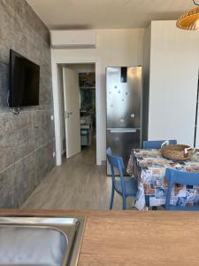 a kitchen and dining room with a table and a television at casa D’ Amare in Marettimo