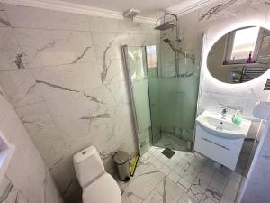 a bathroom with a sink and a toilet and a mirror at Modernt & rymligt sommarhus på landet- Bubbelpool in Eskilstuna +27 photos
