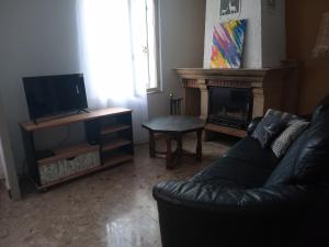 ein Wohnzimmer mit einem Sofa und einem Kamin in der Unterkunft Chez Nanou in Bailleul-sur-ThÃ©rain