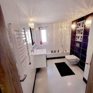 La salle de bains blanche est pourvue d'un lavabo et de toilettes. dans l'établissement Carpe Diem Lakeside Apartment, à Szczecin