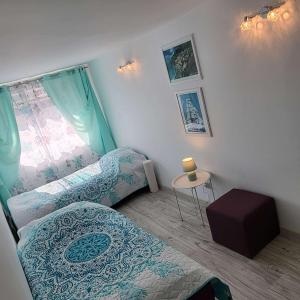 Pokój z 2 łóżkami, stołem i oknem w obiekcie Carpe Diem Lakeside Apartment w Szczecinie