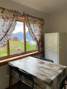 una mesa y sillas en una cocina con ventana en Aurland Stegastein Apartment en Aurland