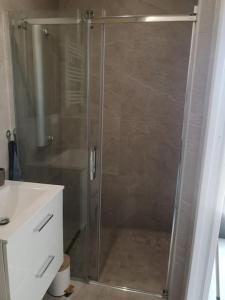 La salle de bains est pourvue d'une douche avec une porte en verre. dans l'établissement Chez Ramses, à Marseille