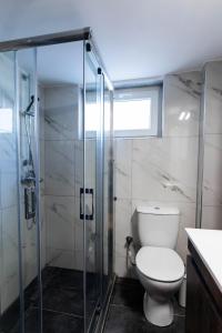 La salle de bains est pourvue de toilettes et d'une douche en verre. dans l'établissement Marilians Luxury Apartment, à Thessalonique