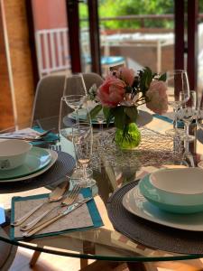 una mesa de cristal con platos y un jarrón de flores en GREEN LAGOON, en Calpe