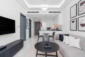 a living room with a couch and a table at Modern one-bedroom in Arjan - Dubaï in Dubai