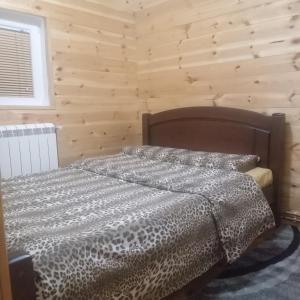 a bed in a room with a wooden wall at Apartments Avramovic in Žabljak