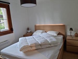 1 dormitorio con 1 cama con sábanas blancas y ventana en Le Cha'let Resteigne, en Wellin
