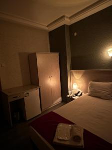 AraklıにあるHotel Ferahのベッドと小さなキャビネット付きのホテルルームです。