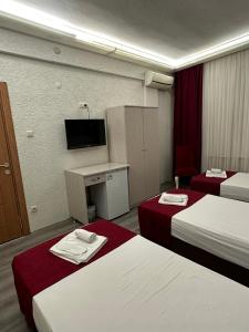 a hotel room with two beds and a tv at Hotel Ferah in Araklı +20 photos