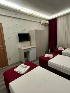 a hotel room with two beds and a tv at Hotel Ferah in Araklı