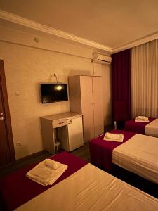 a hotel room with two beds and a flat screen tv at Hotel Ferah in Araklı