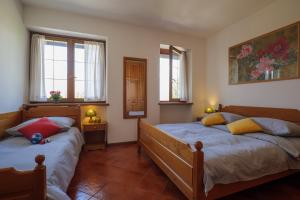 1 dormitorio con 2 camas y 2 ventanas en Villa Palma, en Colico