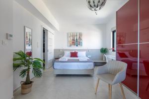 a bedroom with a bed and a chair in it at Crystal Waves lux villa-Homeleader in Chania Town +82 photos