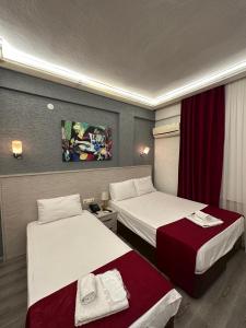 2 camas en una habitación de hotel con cortinas rojas en Hotel Ferah, en Araklı