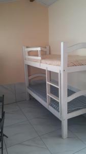 Ce dortoir comprend 2 lits superposés blancs. dans l'établissement Lucena Apartamento Temporada, à Lucena