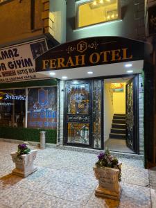 una entrada frontal a una tienda con dos macetas de flores delante en Hotel Ferah, en Araklı