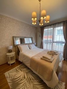 sypialnia z dużym łóżkiem i żyrandolem w obiekcie Home From Home w mieście Sofia
