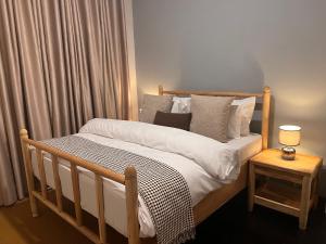 a bedroom with a wooden bed with a side table at Andrella Home Arusha in Arusha