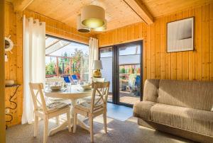 a dining room with a table and a couch at Domek przy morzu in Gąski