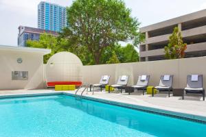 a swimming pool with chairs and a table and a pool at Aloft Atlanta Downtown in Atlanta