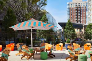 eine Terrasse mit Stühlen, einem Sonnenschirm, Tischen und Stühlen in der Unterkunft Aloft Atlanta Downtown in Atlanta