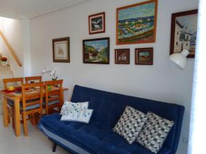sala de estar con sofá azul y mesa en Apartamento ROMERO Cabo Roig, solárium opcional, en Orihuela