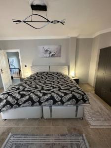 a bedroom with a bed with a black and white comforter at Large Beachfront Villa in Natural Seaside with Sea View in Yukarı Kocaali