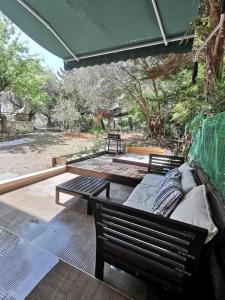 un patio con 2 bancos, una mesa y árboles en ADAMANT STUDIOS, en Nea Moudania