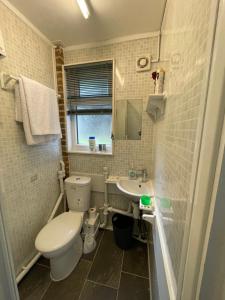 Baño pequeño con aseo y lavamanos en Fantastic Studio, Private bathroom and Mini Kitchen. en Thamesmead