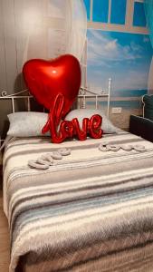 un corazón rojo sentado en la parte superior de una cama en GREEN LAGOON, en Calpe