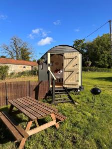 a wooden out house with a picnic table and a grill at The Hideaway in Fakenham