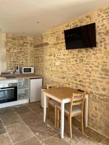cocina con mesa y TV en la pared en Studio Ruben, en Bayeux