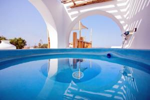 a swimming pool with blue water in a building at Apsenti couples only in Agios Ioannis Mykonos