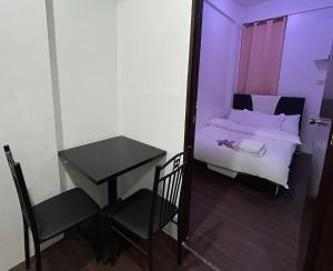 a small room with a bed and a table and chair at Private room with AC and fan at EKG House Rental in Manila