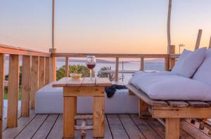 - une table avec un verre de vin sur la terrasse dans l'établissement Apsenti couples only, à Agios Ioannis Mykonos