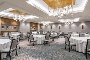 a room with white tables and chairs and chandeliers at Sheraton Reston in Reston