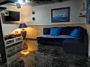 sala de estar con sofá azul y TV en Sunset Abel Anfi Arguineguin, en Mogán