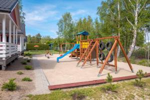 a playground with a slide in a yard at Domki Bruno Mare in Bobolin