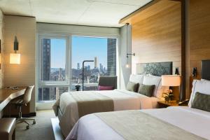 Habitación de hotel con 2 camas y ventana grande. en Renaissance New York Midtown Hotel, en Nueva York